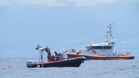 Italian fire service diving crew surface off the coast of Porticello, Sicily amid search for six tourists missing after the luxury yacht Bayesian sank in a storm on Monday