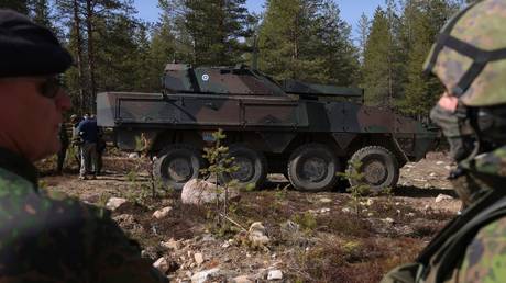 FILE PHOTO: Finnish soldiers stand next to an AMOS 120 armoured mortar vehicle during military exercises.