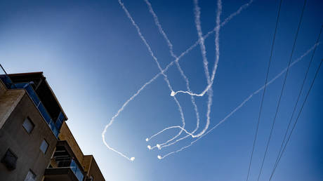 FILE PHOTO: Contrails of Israeli Iron Dome anti-missile defense system strike Hamas rockets overhead as Hamas militants in Gaza continue fire into Israel.