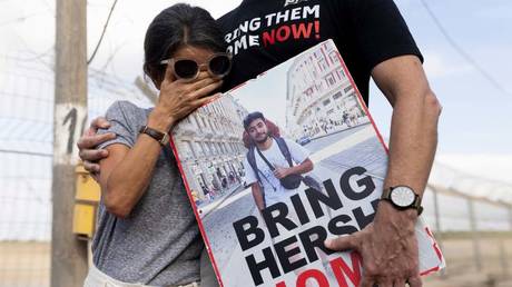 Family members of American-Israeli hostage Hersh Goldberg-Polin, whose body was found in Gaza, are pictured holding a poster with his photograph on August 29, 2024 in Nirim, Israel.