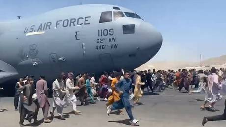 Afghans chase a US Air Force plane as it takes off from Kabul on August 16, 2021