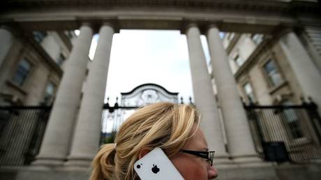 A woman on her Apple iPhone outside Government Buildings in Dublin, Ireland.