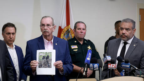 Palm Beach County Sheriff Ric Bradshaw holds a photograph of a rifle and other items discovered after an apparent attempt to assassinate former President Donald Trump on September 15, 2024