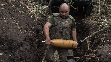 FILE PHOTO: Ukrainian soldier carries 155mm artillery shells during the fighting in Donbass.