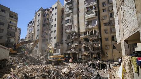 Emergency workers use excavators to clear rubble at the site of an Israeli strike in Beirut's southern suburbs, Lebanon, September 23, 2024