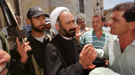 FILE PHOTO: Lebanese Christians voice their concerns to Hezbollah official Sheikh Nabil Qaouk regarding incidents involving Hezbollah fighters looting their houses in Qlaiaa, May 28, 2000.