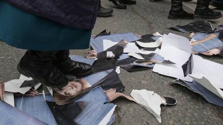 FILE PHOTO: A protester in Chisinau tramples a portrait of Moldovan President Maia Sandu, February 28, 2023.