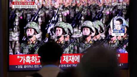 People watch a North Korean military parade on a TV in Seoul, South Korea, October 10, 2020