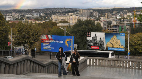 People walk by ruling Georgian Dream party billboards in Tbilisi, Georgia on October 25, 2024.