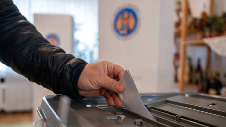 FILE PHOTO: A man casts a ballot in the ballot box at the embassy of the Republic of Moldova.