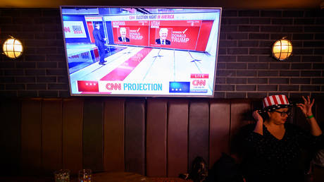 A woman looks away as result projections for Montana and Utah are broadcast during a "Democrats Abroad" election night party on November 06, 2024 in London, England.