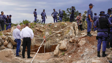 Police officers and private security personnel stand by the opening of a reformed gold mineshaft where illegal miners are trapped in Stilfontein, South Africa, Friday, Nov.15, 2024.