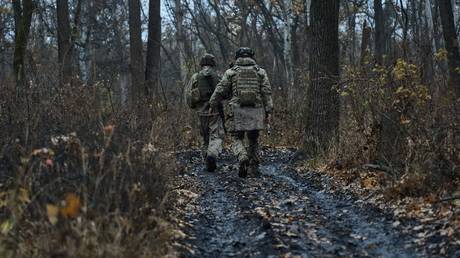  Ukrainian troops walking in a wooded area.