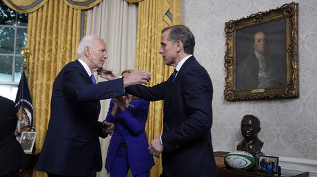  US President Joe Biden hugs son Hunter Biden after addressing the nation from the Oval Office of the White House on July 24, 2024 in Washington, DC.