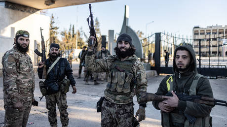 Islamist militants pose outside the captured Military College in the city of Aleppo, December 1,  2024, Syria.