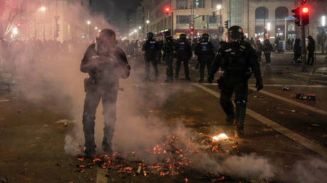 Police put out a fire in the street amid New Year's celebrations in Berlin, Jan. 1, 2025.