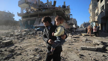 FILE PHOTO. Two Palestinian children are seen in front of a destroyed building as a result of an Israeli attack on the Bureij refugee camp in Gaza City, December 15, 2024.