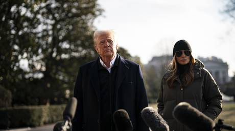 US President Donald Trump talks to reporters flanked by First Lady Melania Trump to his right on the South Lawn of the White House before boarding Marine One in Washington, DC, US, on January 24, 2025.