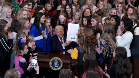 US President Donald Trump, surrounded by women athletes, signs the “No Men in Women’s Sports” executive order in the East Room of the White House on February 5, 2025 in Washington, DC.