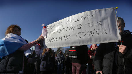 FILE PHOTO: Supporters carry a banner warning against politically correct behaviour that in turn supports grooming gangs as hundreds gather at Telford station in Telford, England.