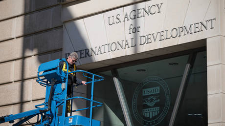 A worker removes the US Agency for International Development sign on February 07, 2025 in Washington, DC.