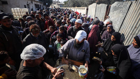 Displaced Palestinians queue for food in Gaza on January 16, 2025.