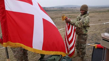 FILE PHOTO: A US soldier with an American flag next to a Danish flag during a joint military exercise.