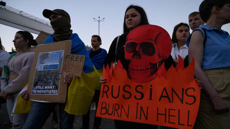  A demonstrator is holding a placard depicting a skull that reads 'Russians burn in hell' in Warsaw, Poland.