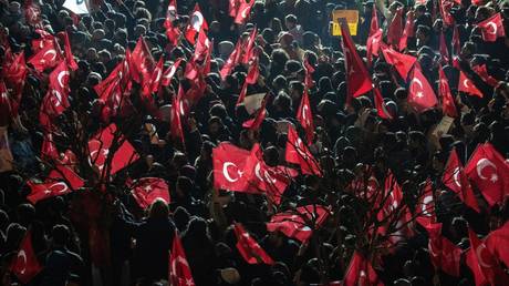 People wave flags and chant slogans during a protest against the arrest of Istanbul mayor Ekrem Imamoglu.