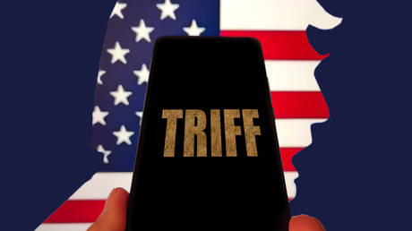 An illustration shows the word 'tariffs' displayed on a smartphone with US President Donald Trump silhouetted in the background.