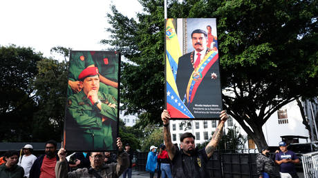 Supporters of Nicolas Maduro and late Hugo Chavez hold posters with their images after explosions and low-flying aircraft were heard on January 03, 2026 in Caracas, Venezuela.