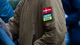 A man wears Danish flag and 'Stand with Ukraine' patches at a rally in Copenhagen, Denmark, February 24, 2026