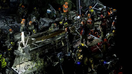 Emergency responders search for survivors following an Iranian ballistic missile strike on April 5, 2026 in Haifa, Israel.