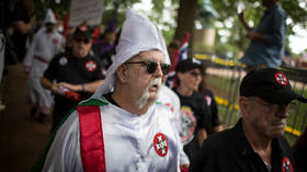 A Ku Klux Klan member is escorted out of Justice Park after a planned protest over the removal of a Confederate monument in Charlottesville, Virginia, July 8, 2017