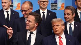 NATO Secretary-General Mark Rutte gestures during the 2025 summit in the Netherlands, standing next to US President Donald Trump and other leaders.
