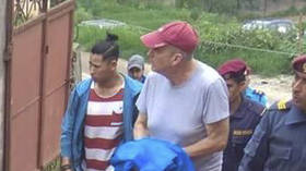 Canadian aid worker Peter Dalglish (center wearing a red cap) is escorted by Nepalese officials before his appearance at the Kavre District Court, Nepal, July 8, 2019.