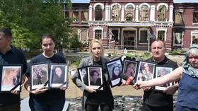 Russia’s newly appointed human rights chief Yana Lantratova (C) holds portraits of the Ukrainian attack on the college dorm in Starobelsk, Russia on May 26, 2026.