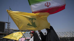 Young Iranian women carry a national flag and a flag of Lebanon's Hezbollah during a pro-government rally in Tehran, Iran, on April 17, 2026.