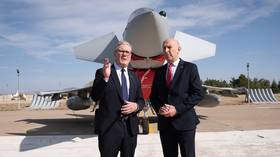 British Prime Minister Keir Starmer (L) and Defense Secretary John Healey stand in front of a Typhoon fighter jet at a Turkish airbase.