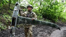 A Russian military service member holds a Ukrainian Shark mini drone downed by a Tor M-1 air defense system.