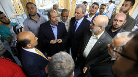 Hamas' Khalil al-Haya (L2) and then-Minister of Housing and Public Works of Palestinian National Consensus Government Mufid al-Hasayni (L), visit wounded Palestinians at Al-Shifa Hospital, in Gaza city, Gaza on 14 August, 2014.