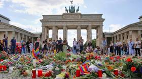 Mourners lay flowers in front of the Brandenburg Gate in Berlin, Germany, to commemorate the victims of an attack on the city gay pride parade on July 28, 2026.