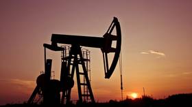 An industrial oil pumpjack in the sunset.