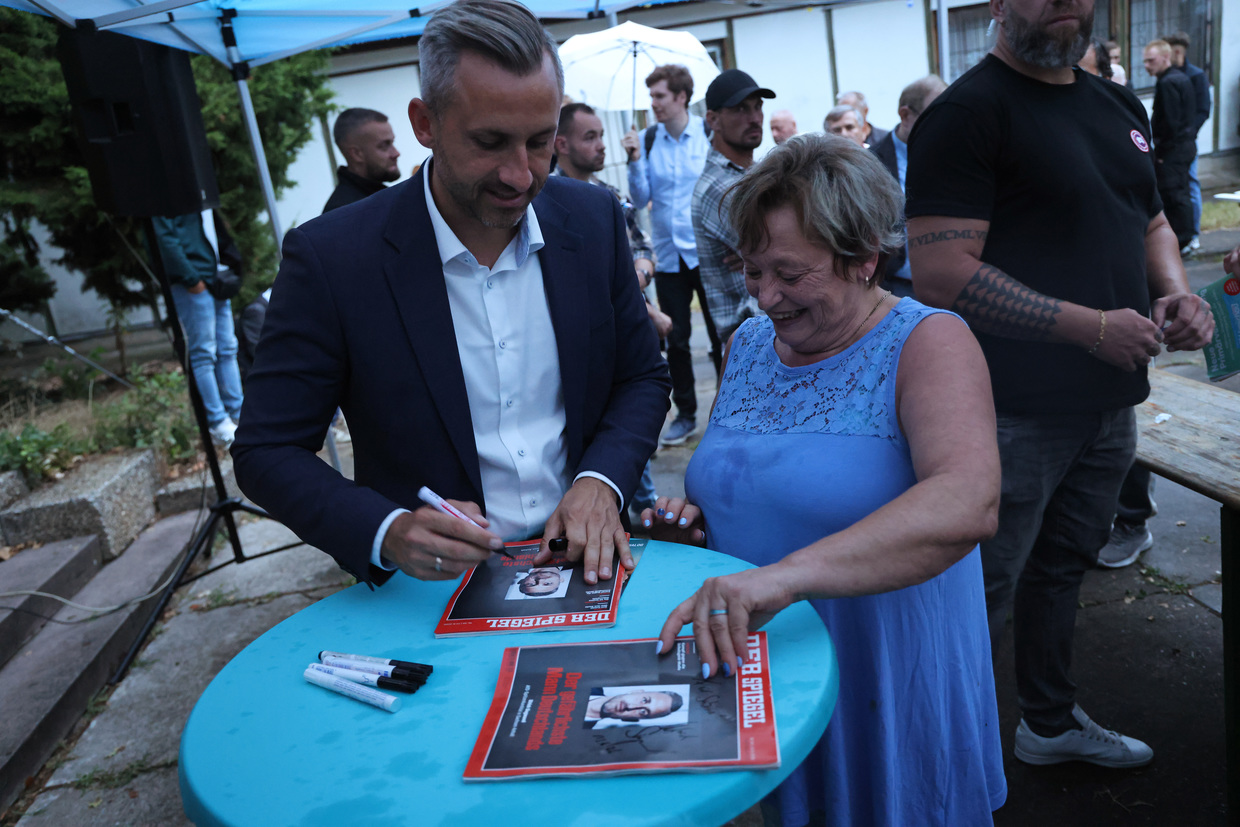 The AfD's lead candidate at the Saxony-Anhalt regional vote, Ulrich Siegmund, autographs Der Spiegel copies at a campaign event in Dessau-Rosslau, Germany, August 19, 2026.