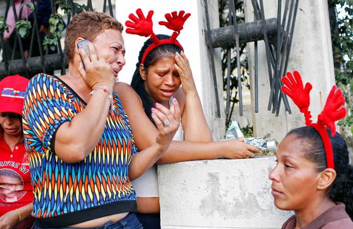 Supporters of Venezuela's President Hugo Chavez react to the announcement of his death outside the hospital where he was being treated in Caracas, March 5, 2013 (Reuters / Carlos Garcia Rawlins)