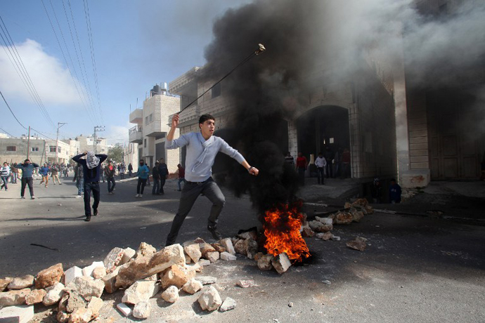 A Palestinian protester uses a slingshot to hurl stones towards Israeli security forces during clashes in the village of Saair, east the West Bank city of Hebron, on February 24, 2013. (AFP Photo / Hazem Bader)