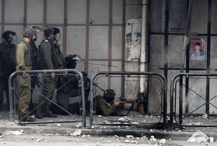 Israeli soldiers take position during clashes with stone-throwing Palestinian protesters in the West Bank city of Hebron February 24, 2013. (Reuters / Ammar Awad)