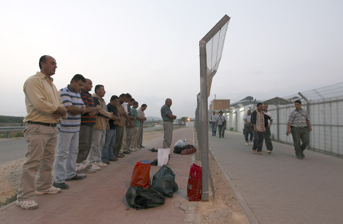 Palestinian labourers pray after crossing through Israel's Eyal checkpoint near the West Bank town of Qalqilya (Reuters/Baz Ratner)