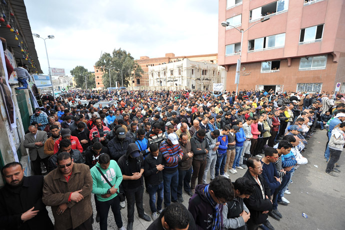 People pray during the funeral of three people killed in overnight clashes with police on March 4, 2013 in the Egyptian canal city of Port Said. (AFP Photo)