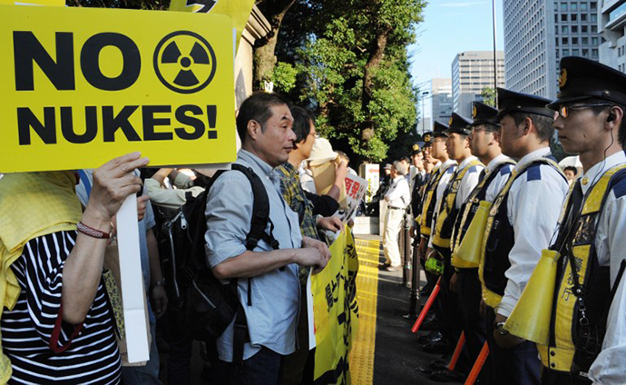 People hold placards in front of policemen during a demonstration in downtown Tokyo on October 13, 2012 denoucing the Japanese government's plan to resume nuclear power use after halting operations after last year's Fukushima crisis. (AFP Photo / Rie Ishii)